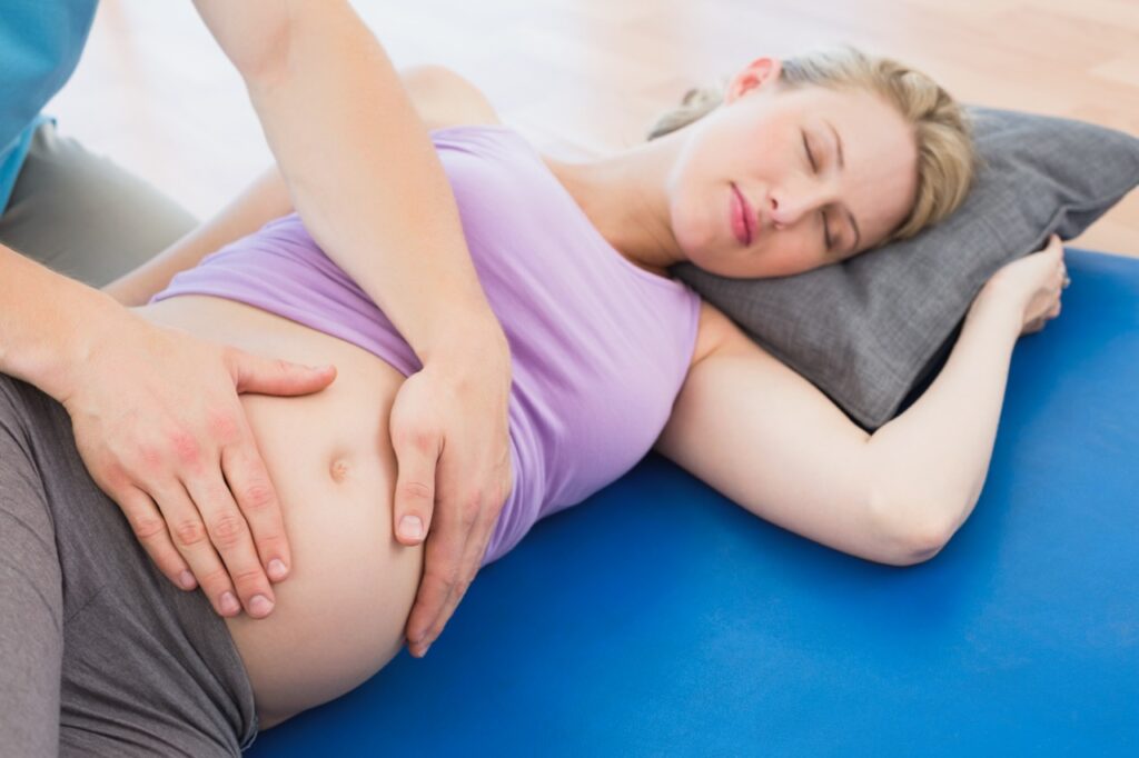 Peaceful pregnant woman having a relaxing massage in a studio